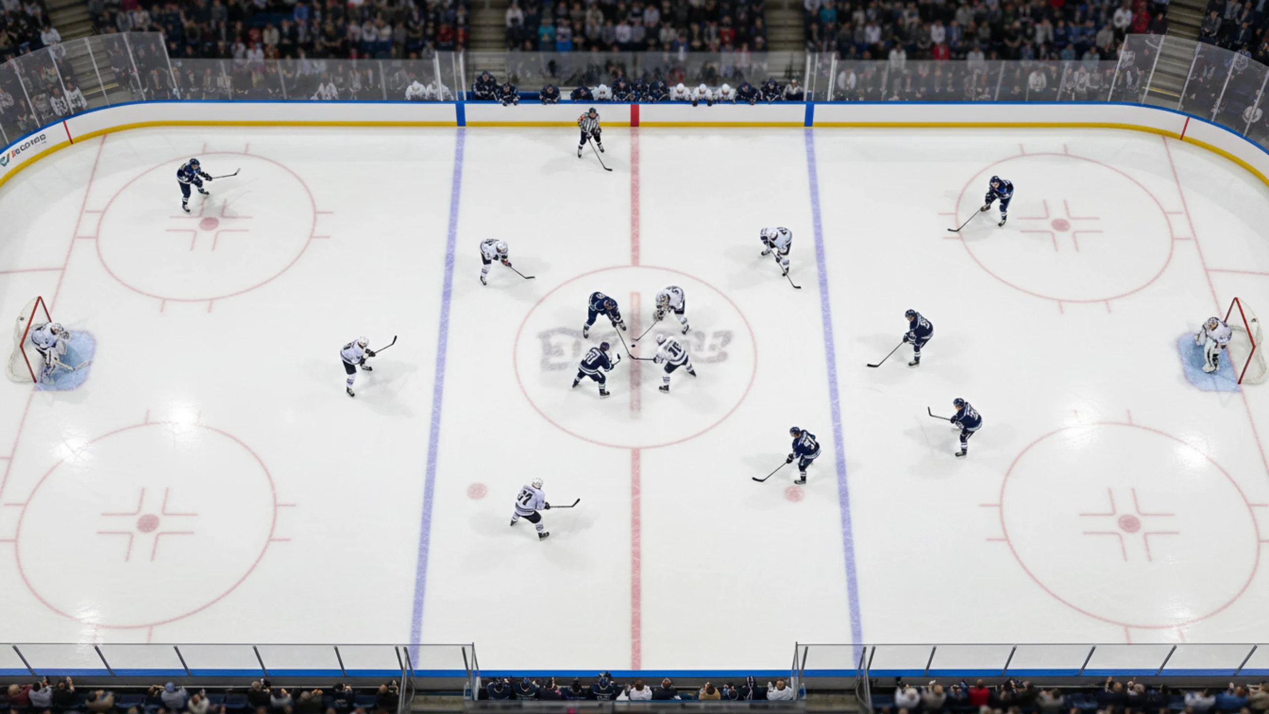 Luftaufnahme eines NHL-Eishockeyfelds mit strategischer Spielerpositionierung während eines Faceoffs